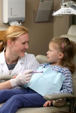 Image of a dentist examining a preschool girl's teeth