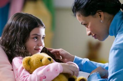 Mother putting daughter to bed