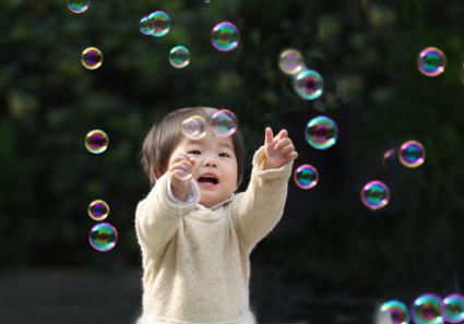 Girl Chasing Colorful Bubbles