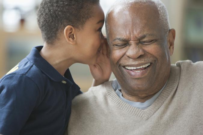 Boy telling grandfather a secret