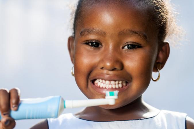 girl holding electric toothbrush