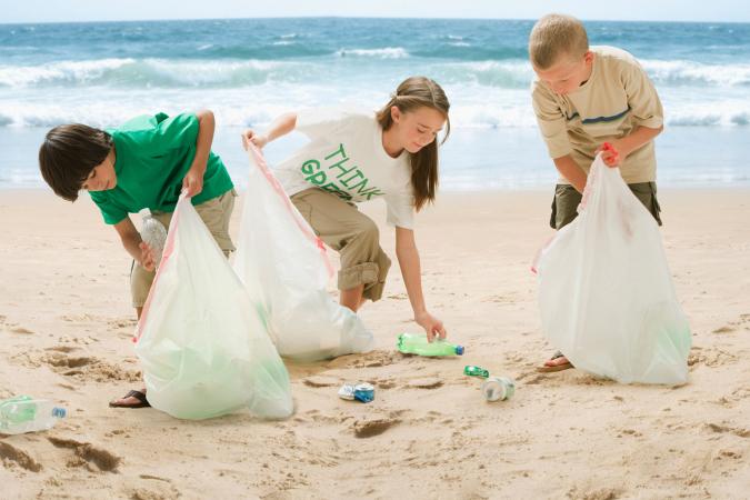 Kids picking up trash on beach