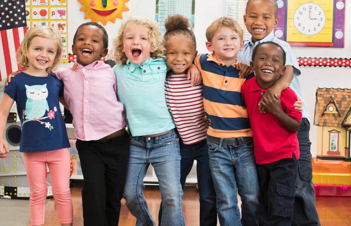 Kindergarten students hugging in classroom