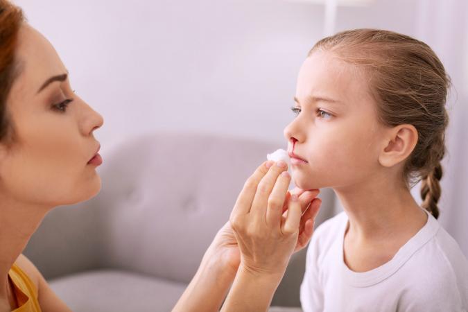 Mother tending to child's nose bleed