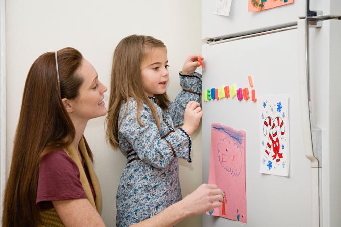 Mother and daughter hanging fridge art