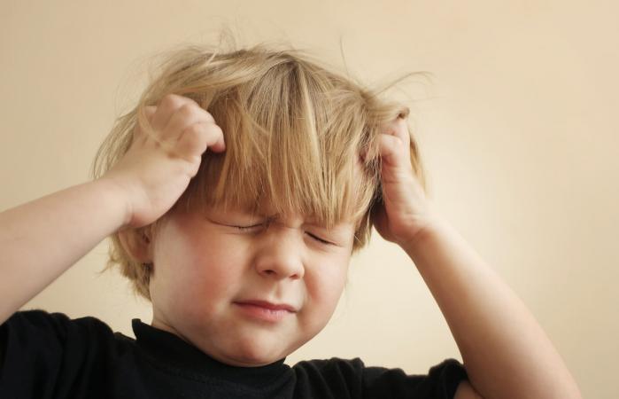 Boy scratching his head