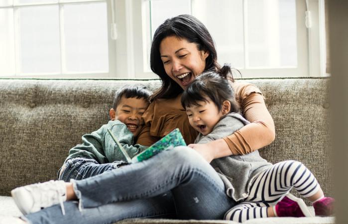 Mother reading funny riddles to kids