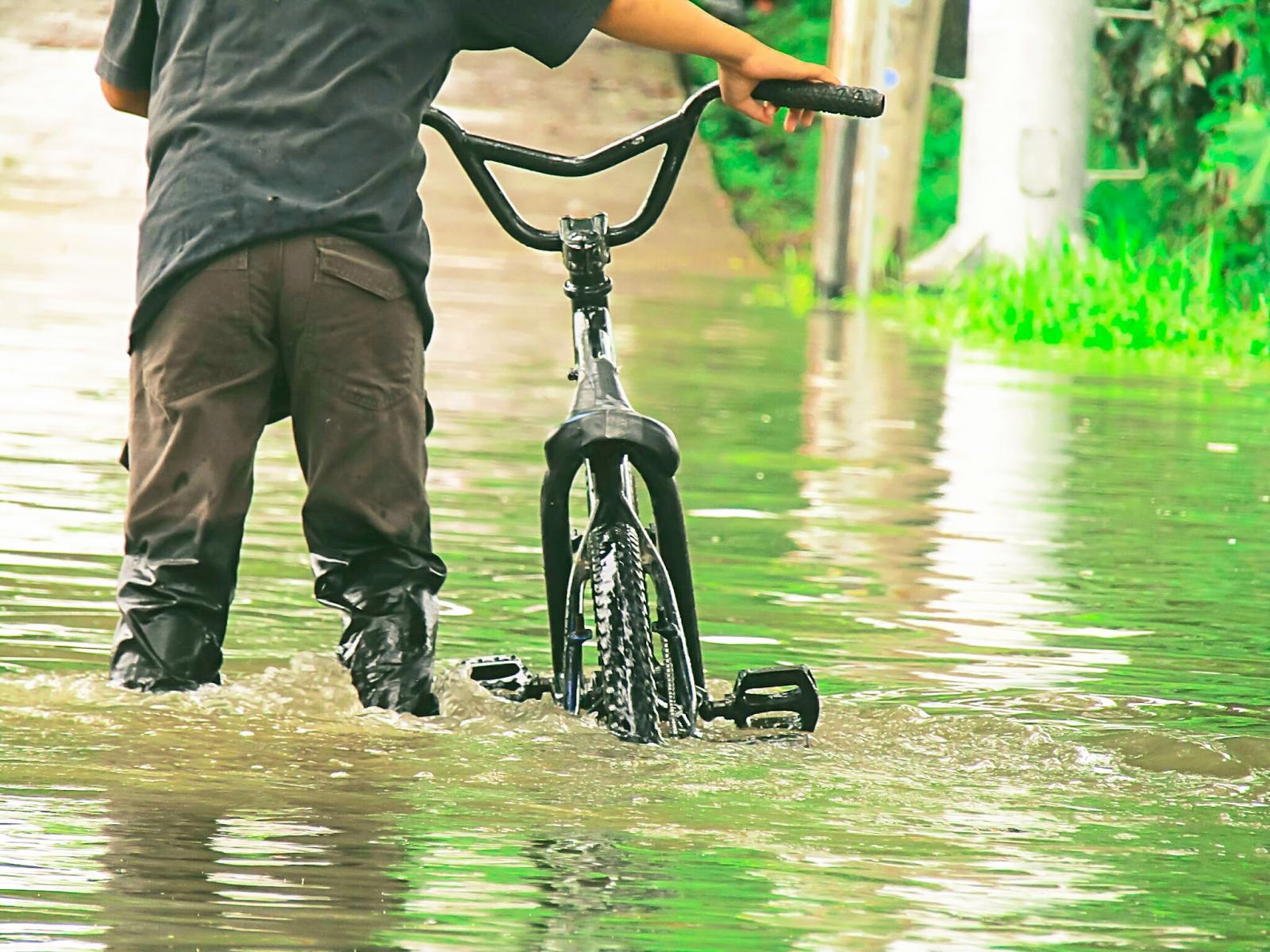 Man With Bicycle Standing In Water