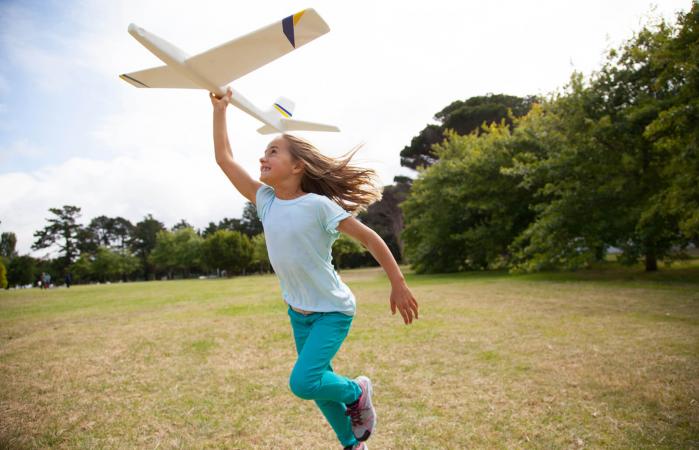 Girl running in park with plane