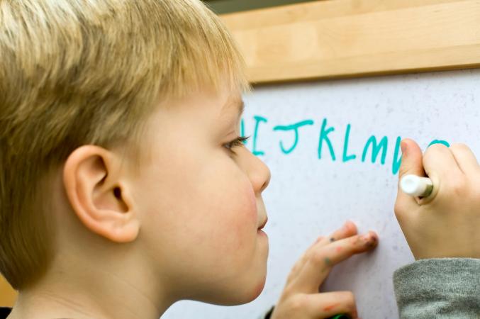 kid writing alphabet
