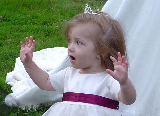 Girl with hands raised doing fingerplays