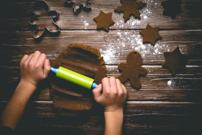 Child rolling out gingerbread cookie dough