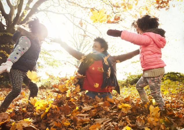mom and kids playing in the leaves