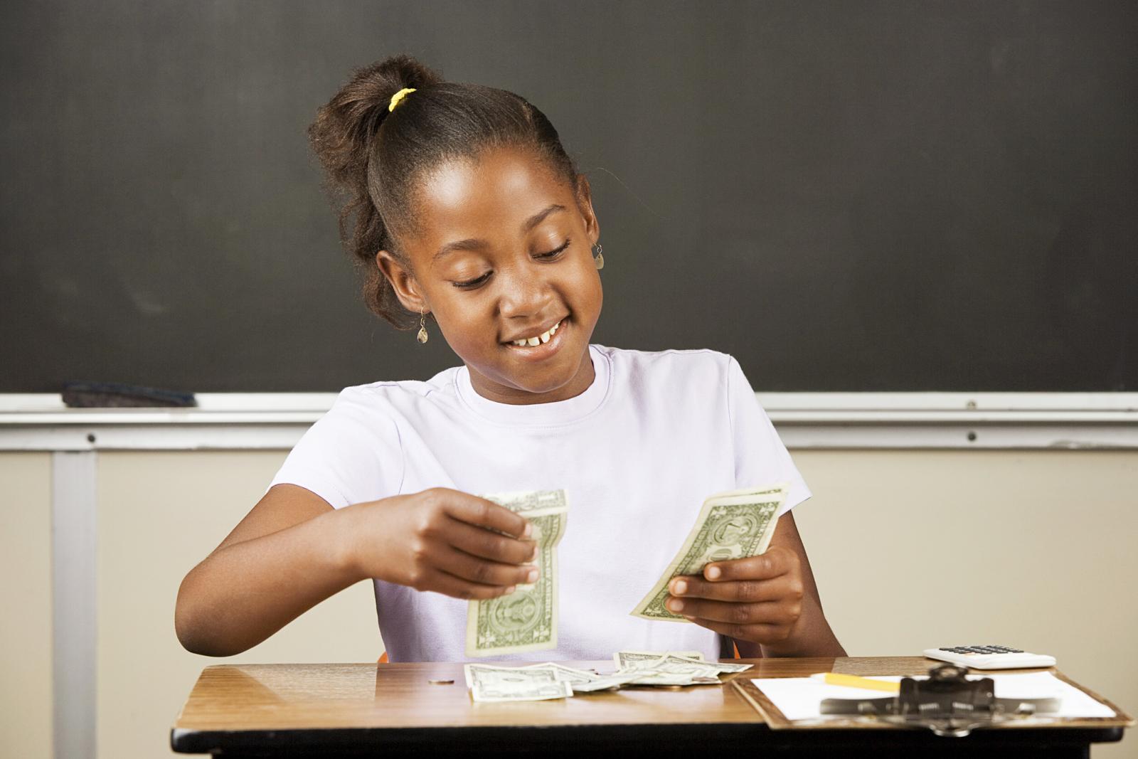 Student counting money on a desk