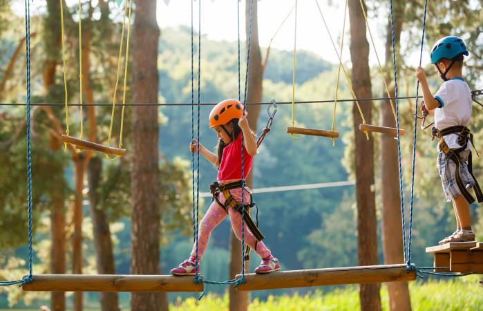 Boy and girl walk on a rope bridge