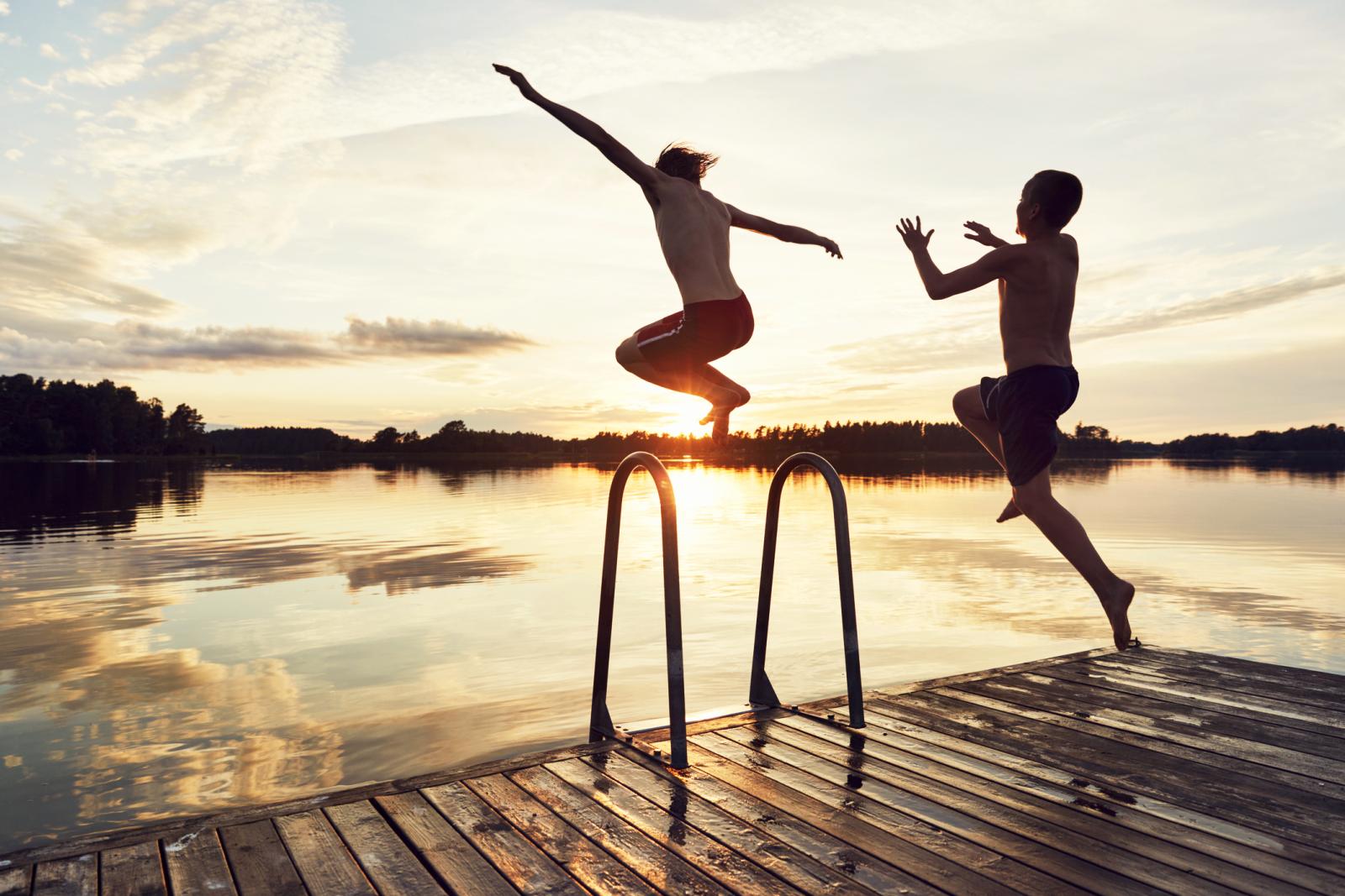 Boys jumping into lake