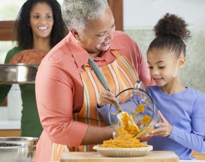 Three generations of Black women cooking in kitchen