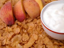 Healthy snack of peaches, yogurt, and corn flakes