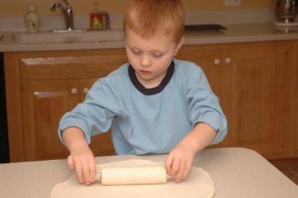 Boy rolling out cookie dough