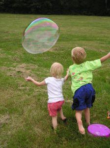 Image of children chasing their giant soap bubble