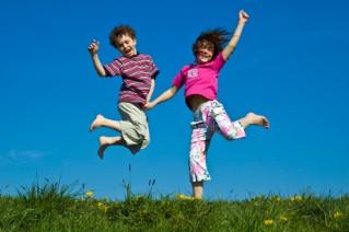 Kids jumping outside on a sunny day