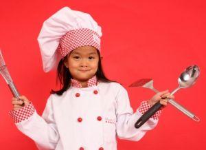 Image of a child chef holding cooking utensils
