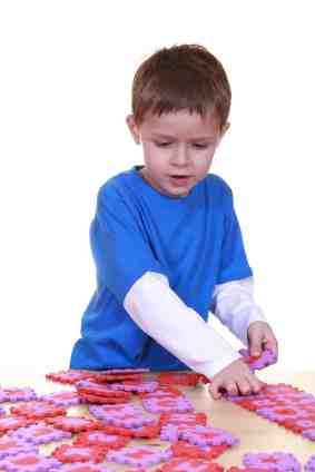 Boy playing with alphabet puzzle at daycare