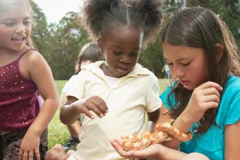 three girls playing with a small snake