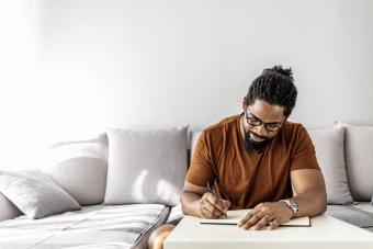 man writing in his journal