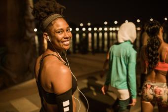 Woman smiling at camera while she's on night walk with friends