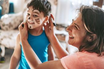 Mom is doing face painting for her son
