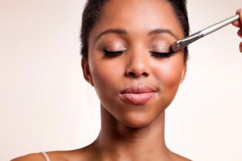 Woman having eyeshadow applied on her face