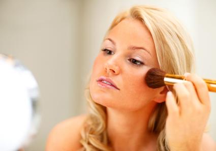 Applying blush to cheeks
