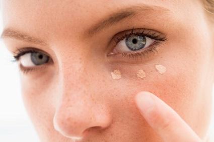 Woman applying eye concealer