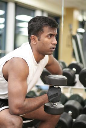 A weightlifter in a sleeveless shirt working out.