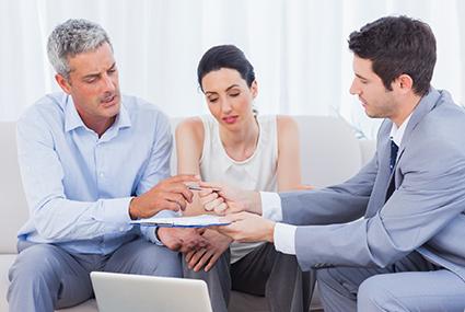 Couple filling out application with mortgage broker