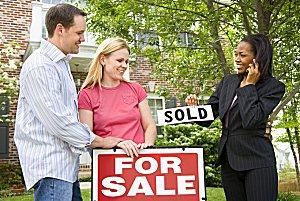 Agent putting "sold" over for sale sign