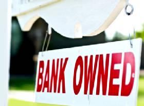 "Bank Owned" for sale sign in yard