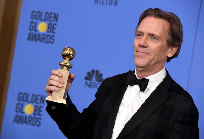Hugh Laurie holding an award
