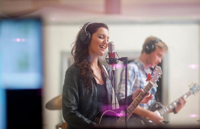 Young band playing music in recoding studio