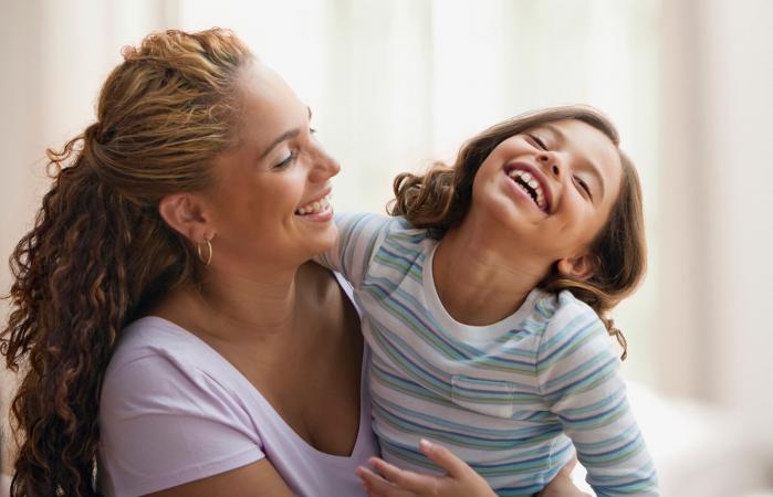 Madre abrazando y riendo con su hija
