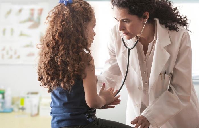 Pediatra examinando niña