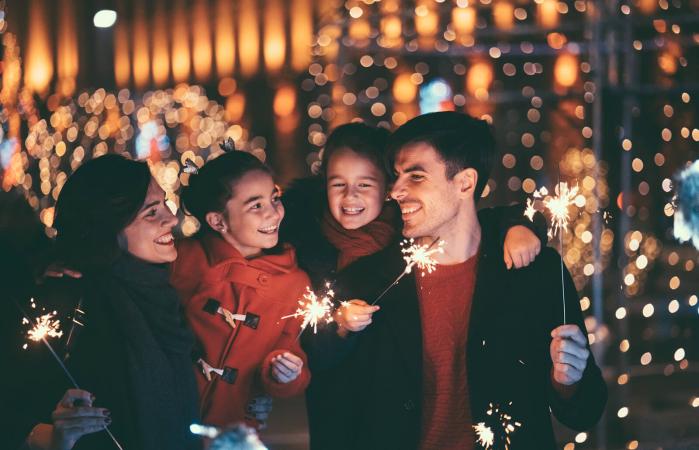 Familia feliz con bengalas encendidas