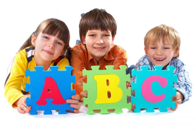 Niños con rompecabezas gigante del alfabeto
