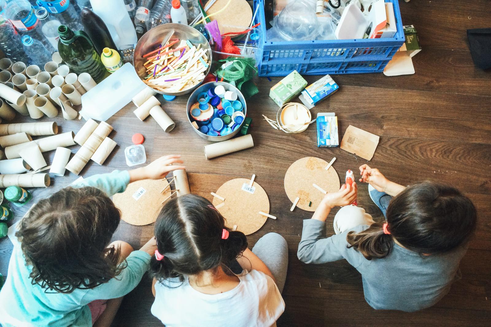 Niños haciendo manualidades con material reciclado