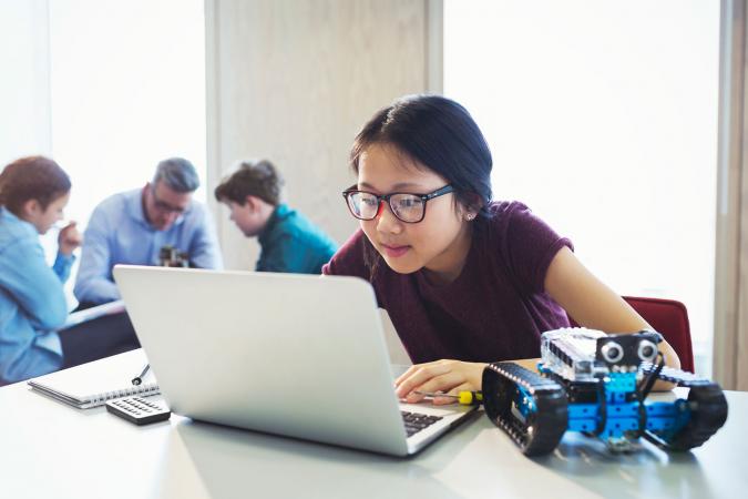 Chica en computadora con robot
