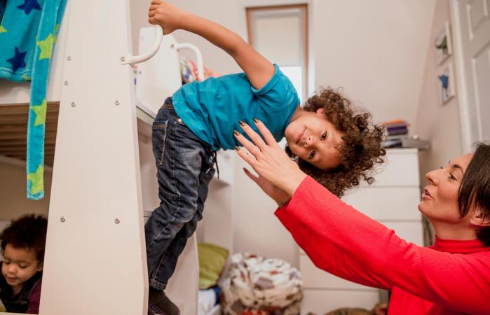 Niño inclinado hacia abajo con mamá listo para atraparlo