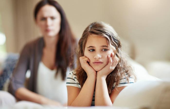 Niña siendo reprendida por su madre en casa