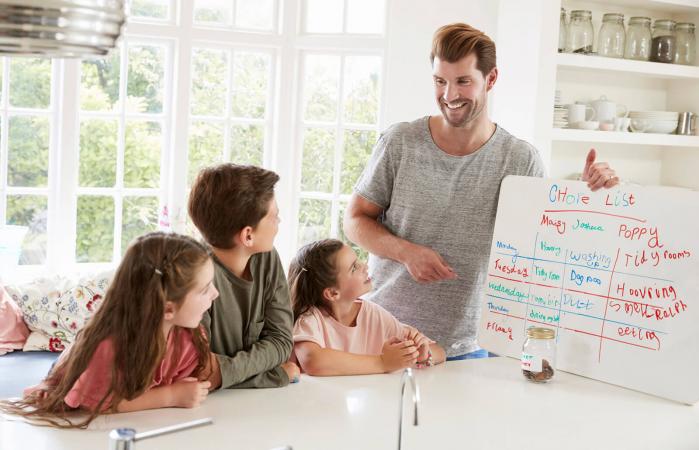 Niños que reciben dinero después de completar la lista de tareas
