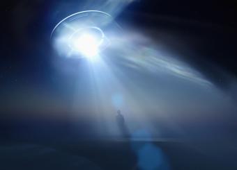 Image of alien ship abducting a person